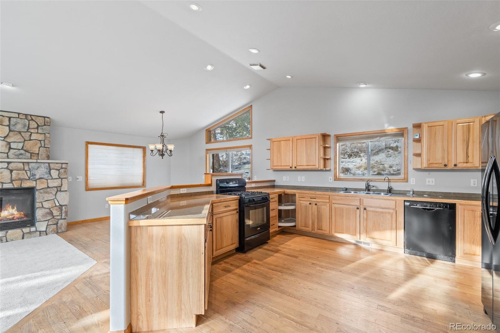 377 Deer Trail Drive Bailey, CO 80421 - Photo 11 of 44 a kitchen with stainless steel appliances granite countertop a stove top oven a sink dishwasher and wooden cabinets