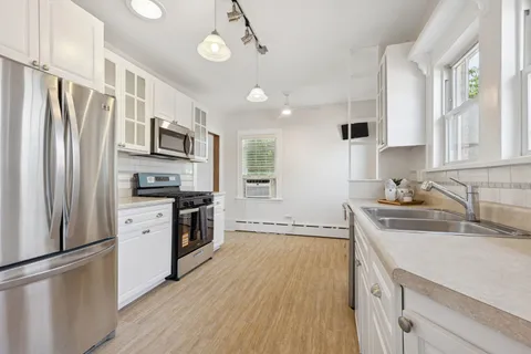 a kitchen with a refrigerator a sink a stove and cabinets