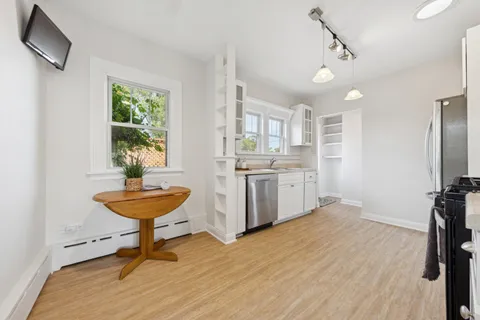 a room with chandelier fan and windows