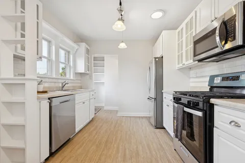 a kitchen with stainless steel appliances granite countertop a stove and cabinets