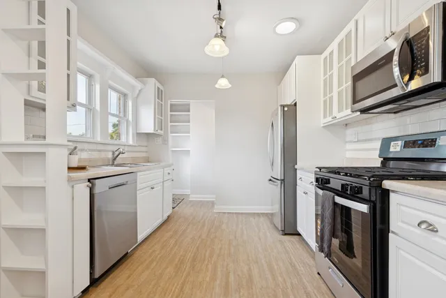 a kitchen with stainless steel appliances granite countertop a stove and cabinets