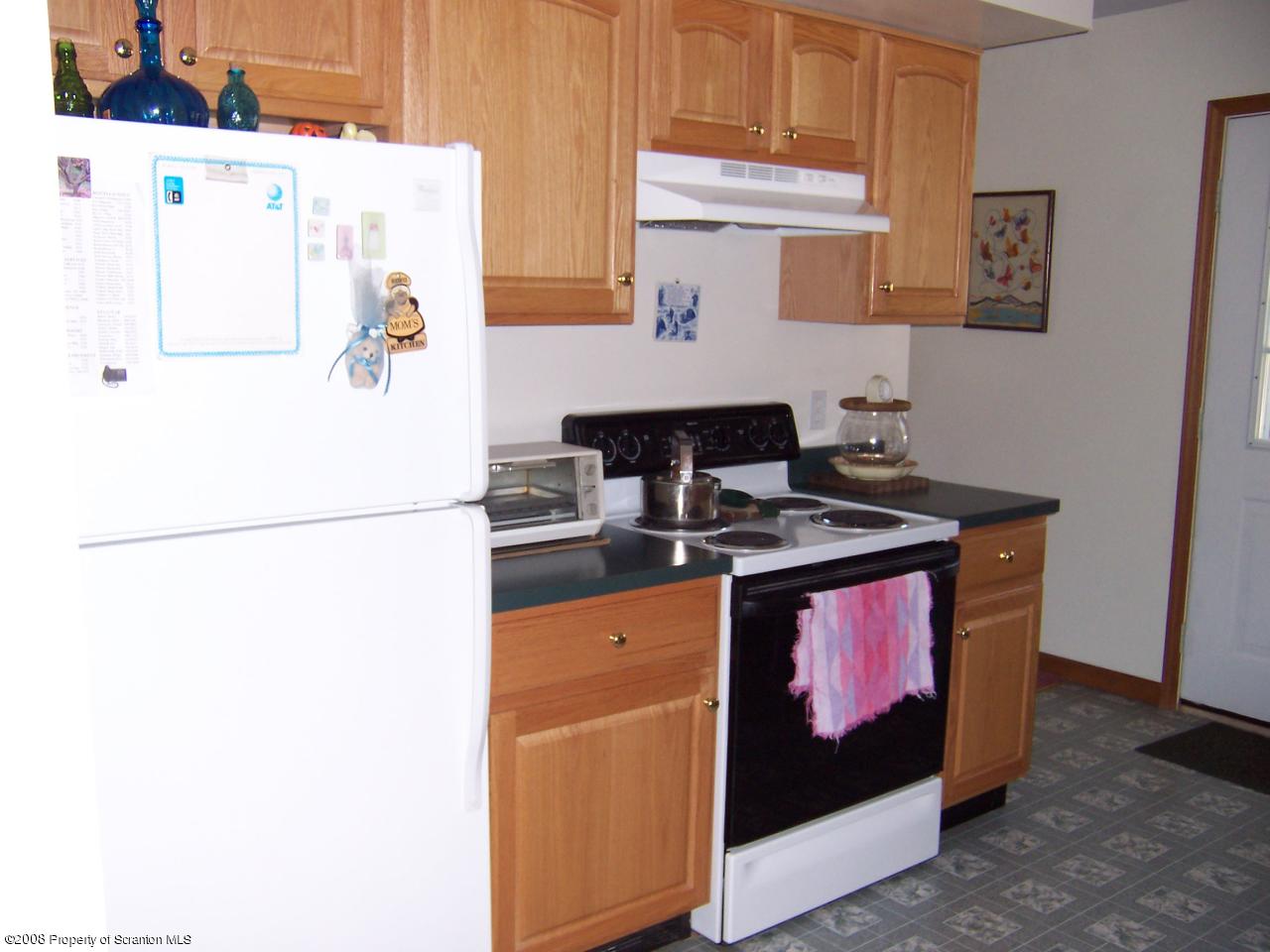 25 Cemetery Road Moscow, PA 18444 - Photo 7 of 14 a kitchen with granite countertop a refrigerator a stove a sink and white cabinets