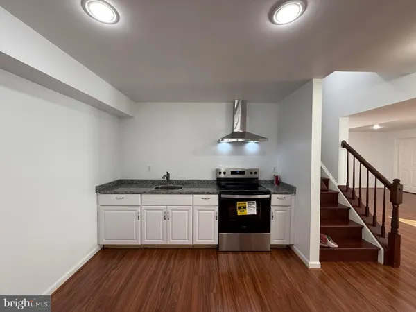 a kitchen with stainless steel appliances a stove and wooden floor