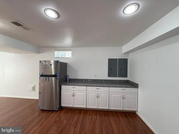 a kitchen with stainless steel appliances a refrigerator and wooden floor