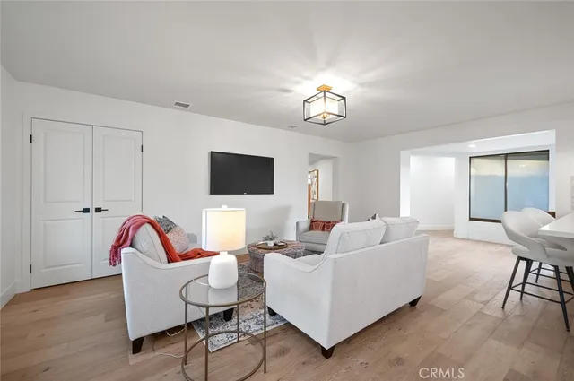 a living room with furniture a flat screen tv and a window