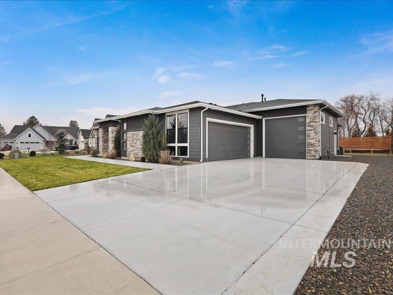 3882 West Haverhill Street Eagle, ID 83616 - Photo 1 of 38 View of front of property with stone siding, an attached garage, driveway, and a front yard
