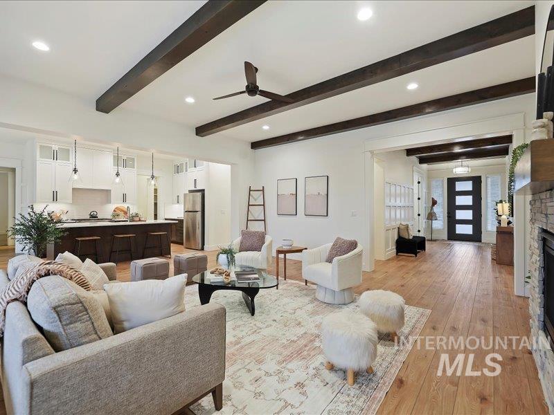 3882 West Haverhill Street Eagle, ID 83616 - Photo 12 of 38 Living room with ceiling fan, light wood finished floors, a stone fireplace, recessed lighting, and beamed ceiling