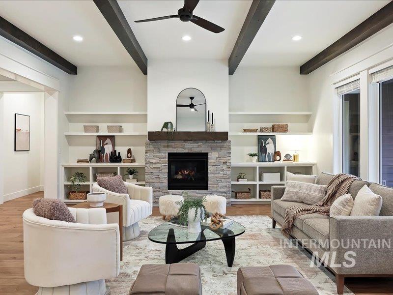 3882 West Haverhill Street Eagle, ID 83616 - Photo 10 of 38 Living room featuring beam ceiling, ceiling fan, a stone fireplace, recessed lighting, and built in features