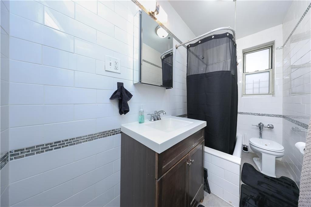 9281 Shore Road, Unit 220 Brooklyn, NY 11209 - Photo 17 of 17 a bathroom with a sink toilet and shower