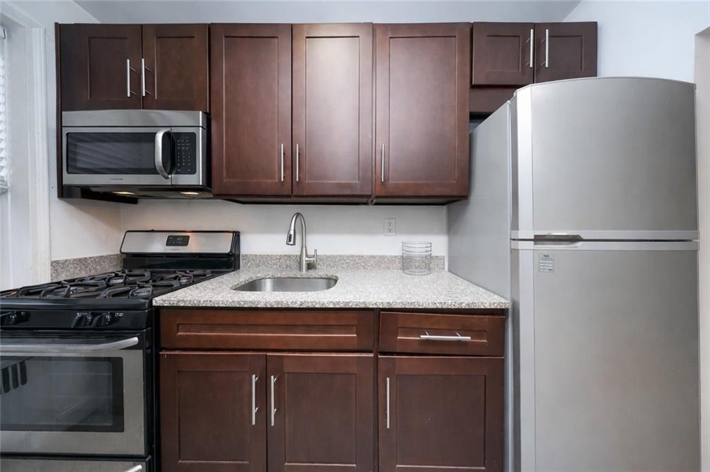 9281 Shore Road, Unit 220 Brooklyn, NY 11209 - Photo 7 of 17 a kitchen with a sink stove and microwave