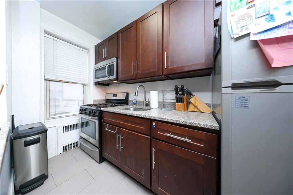 9281 Shore Road, Unit 220 Brooklyn, NY 11209 - Photo 8 of 17 a kitchen with stainless steel appliances granite countertop a sink stove and refrigerator
