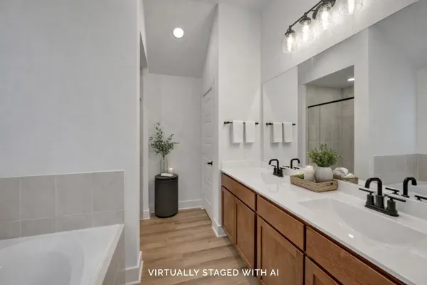 a bathroom with a double vanity sink a mirror and a bathtub