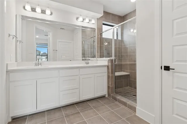 a spacious bathroom with a shower sink and mirror