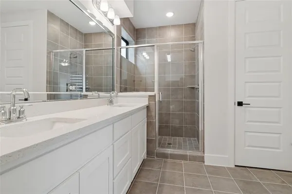 a bathroom with a shower sink and mirror