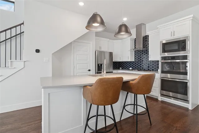 a kitchen with stainless steel appliances granite countertop a stove a sink and a refrigerator