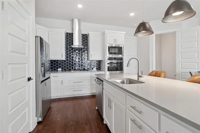 a kitchen with white cabinets and sink