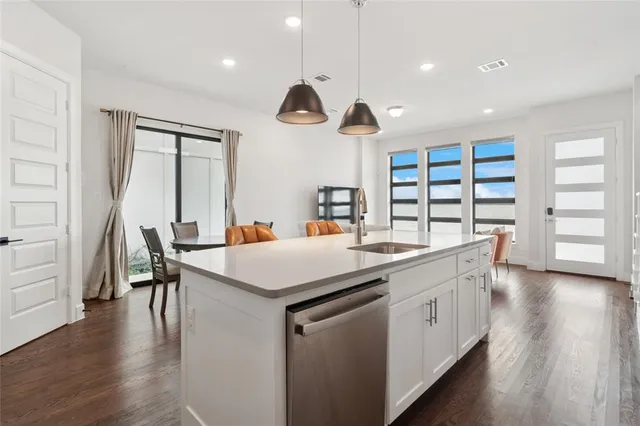 a kitchen with a table chairs and wooden floor