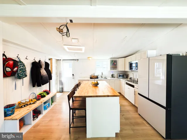 a kitchen with stainless steel appliances kitchen island wooden cabinets and refrigerator
