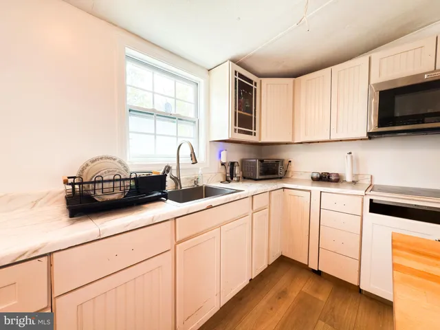 a kitchen with sink a microwave and cabinets
