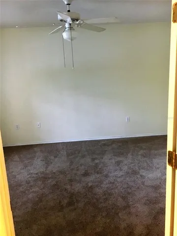 a view of wooden floor and chandelier fan in an empty room