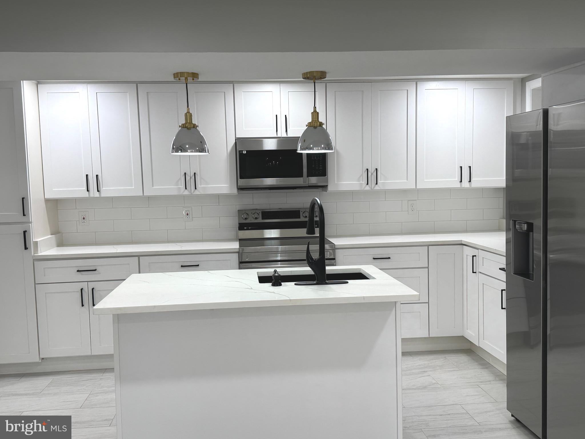 1319 C Street Northeast, Unit B Washington, DC 20002 - Photo 4 of 14 a kitchen with appliances a sink and a counter top space