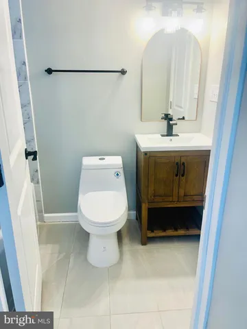 a bathroom with a toilet a sink and mirror
