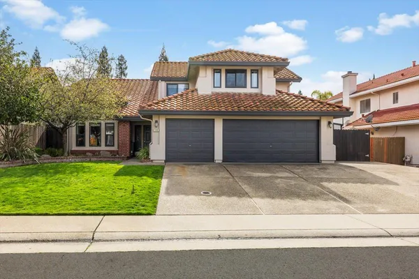 a front view of a house with a garden and garage