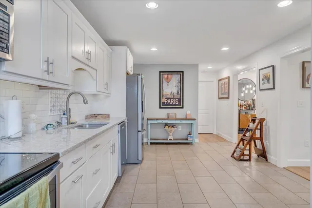 a view of kitchen with stainless steel appliances granite countertop a sink and cabinets
