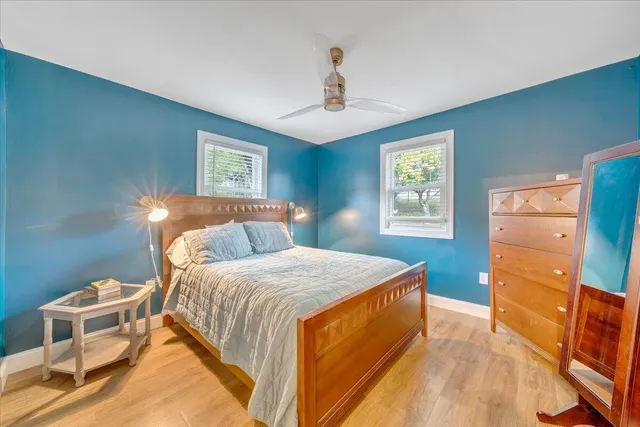 a bedroom with a bed and a lamp on dresser