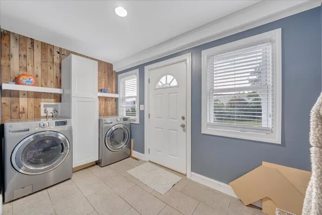 a view of a bedroom with washer and dryer to ceiling window