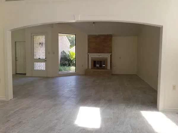 an empty room with windows fire place and fireplace