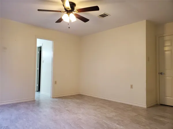 an empty room with closet and a chandelier fan