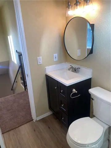 a bathroom with a toilet a sink a mirror and a rug