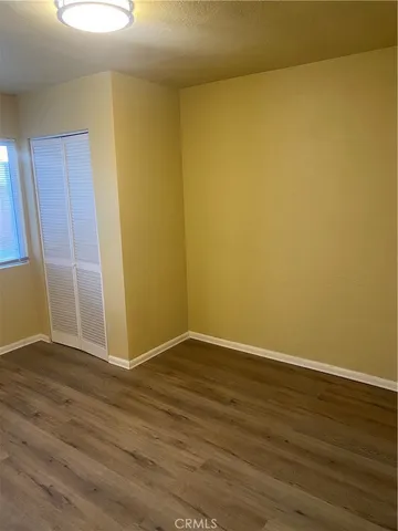 an empty room with wooden floor and door