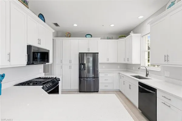a kitchen with stainless steel appliances a refrigerator sink and microwave