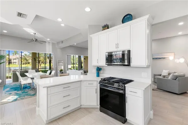 a kitchen with stainless steel appliances white cabinets and a stove top oven