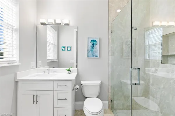 a bathroom with a sink a toilet and shower