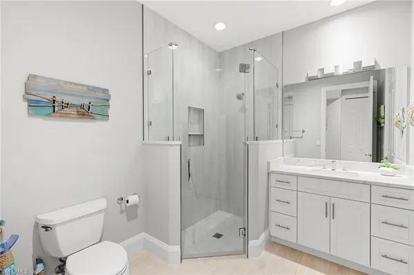 a bathroom with a shower sink vanity mirror and toilet