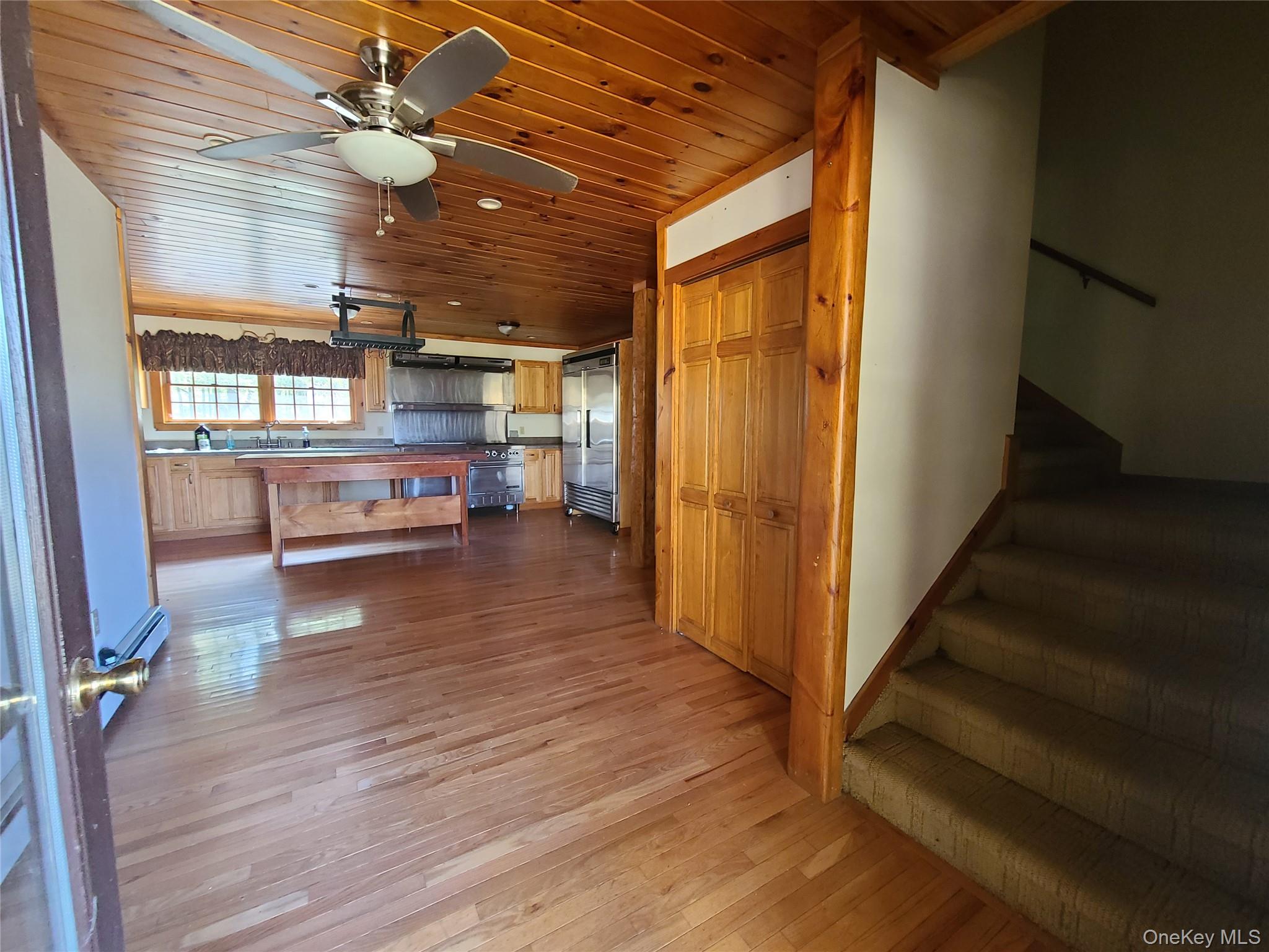 118 Hilltop Road Monticello, NY 12701 - Photo 12 of 45 a view of a livingroom with wooden floor and a ceiling fan