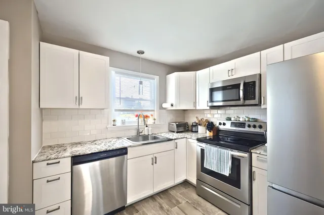 a kitchen with a sink stove and white cabinets