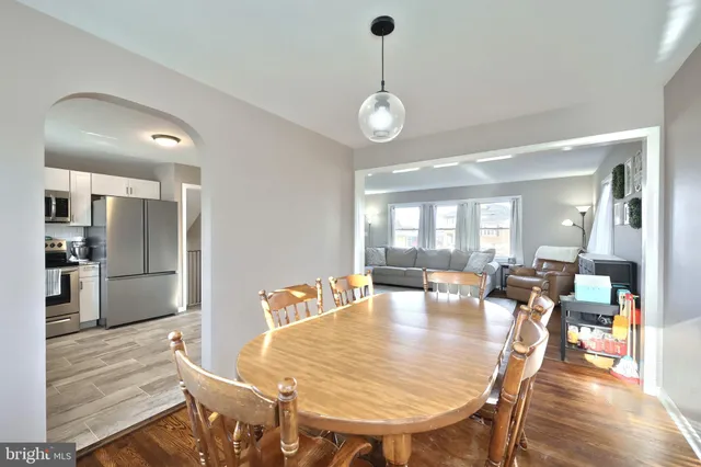 a view of a dining room and livingroom with furniture wooden floor a chandelier