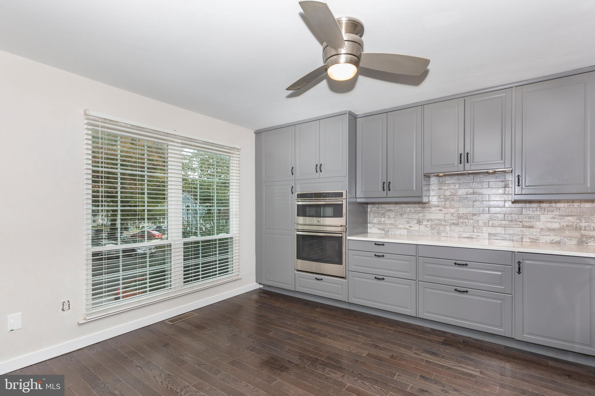 7459 Setting Sun Way Columbia, MD 21046 - Photo 4 of 33 a kitchen with granite countertop white cabinets and stainless steel appliances