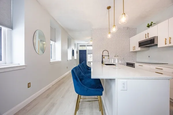 a kitchen with a white center island and windows