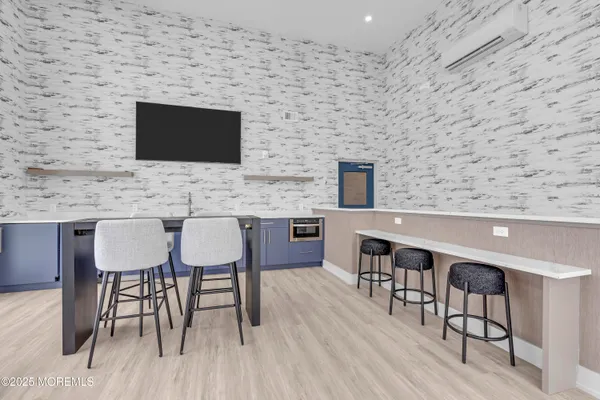 a living room with couches chandelier and a dining table with wooden floor