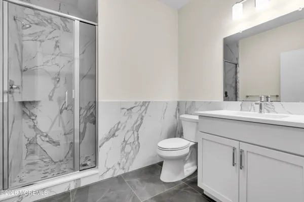 a bathroom with a sink toilet a mirror and shower