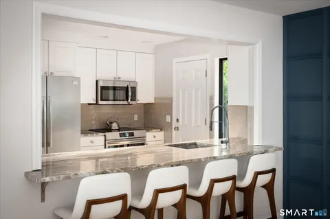 a kitchen with a dining table chairs and microwave