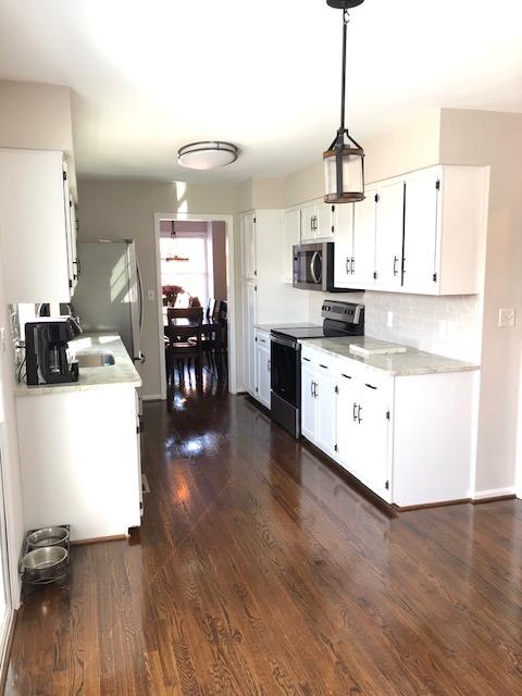 308 North Preston Road Vinton, VA 24179 - Photo 9 of 29 a kitchen with stainless steel appliances a stove top oven a sink a refrigerator a dining table and chairs with wooden floor