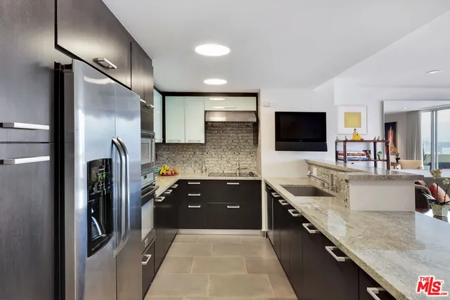 a kitchen with stainless steel appliances granite countertop a sink a stove and a refrigerator