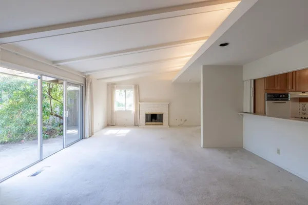 a view of empty room with a fireplace and windows