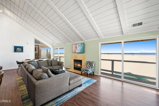 a living room with furniture large window and wooden floor